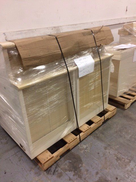 Wrapped cardboard boxes on wooden pallets in a warehouse storage area.
