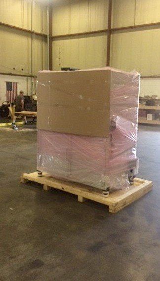 Wrapped cardboard boxes on a wooden pallet in a warehouse