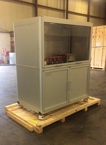 Gray industrial cabinet on a wooden pallet in a warehouse.