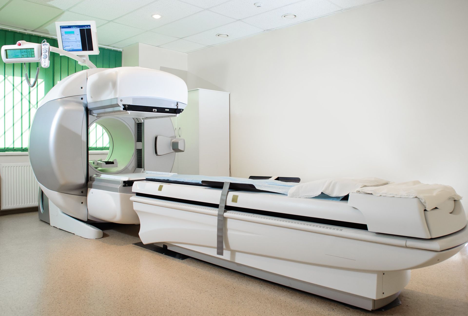 Hospital CT scanner with patient table in a bright clinical room