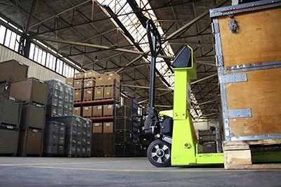 Yellow forklift beside stacked boxes in a warehouse