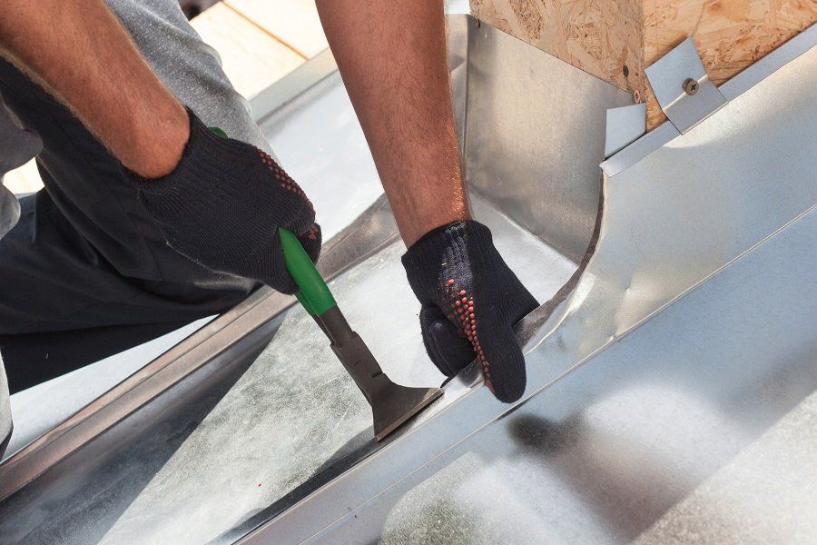 Residential Roofing — Man Repairing Downspout in Harrisburg, SD Residential Roofing — Man Repairing Downspout in Harrisburg, SD