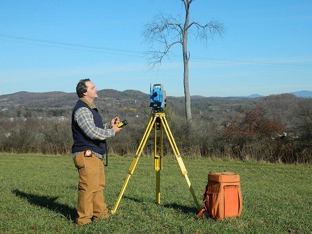 Man Facing To The Right Setting Up The Theodolite On Field — Greenwich, NY — Corner Post Land Surveying