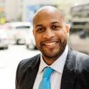 A man in a suit and tie is smiling for the camera