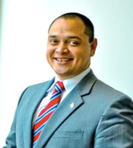 A man in a suit and tie is smiling for the camera
