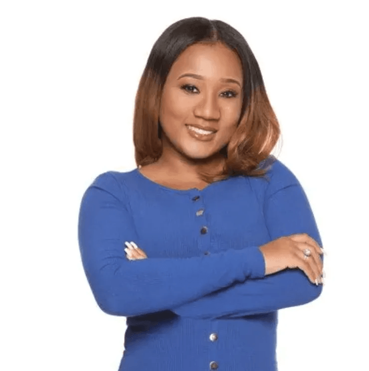 A woman in a blue shirt with her arms crossed