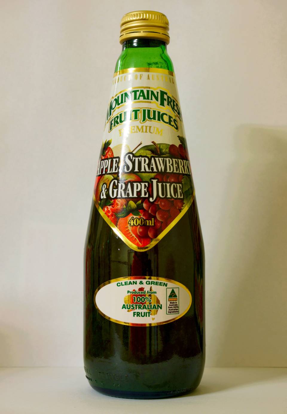 Bottle of grape juice with green and red label on a plain background