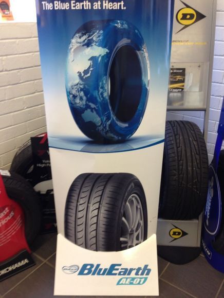 Display advertising BluEarth tires. The design shows a tire shaped like the Earth, and a view of a tire tread.