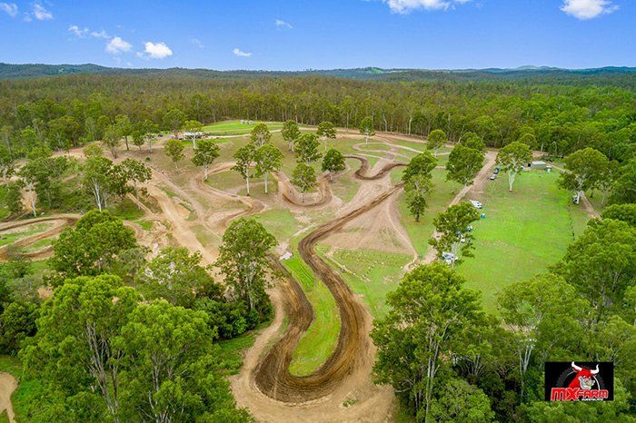 An aerial view of a dirt track in the middle of a forest.
