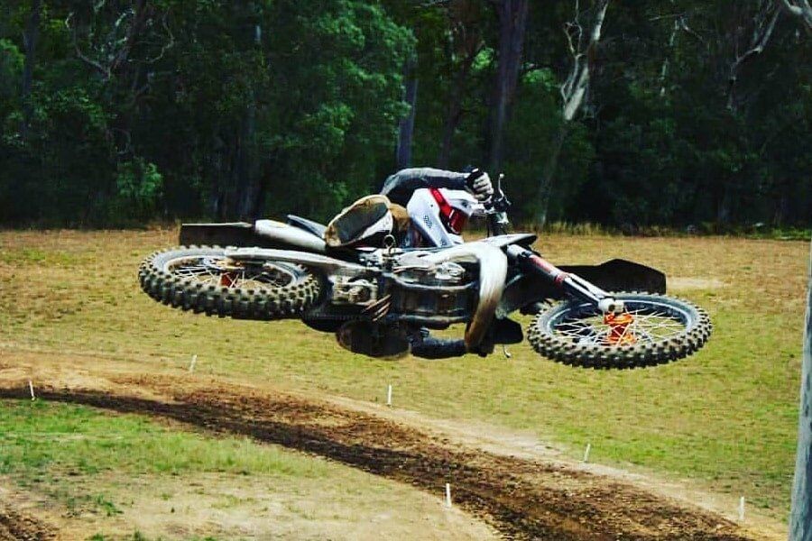 A person is riding a dirt bike on a dirt track.