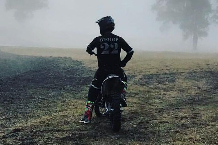 A person is riding a dirt bike in the fog.