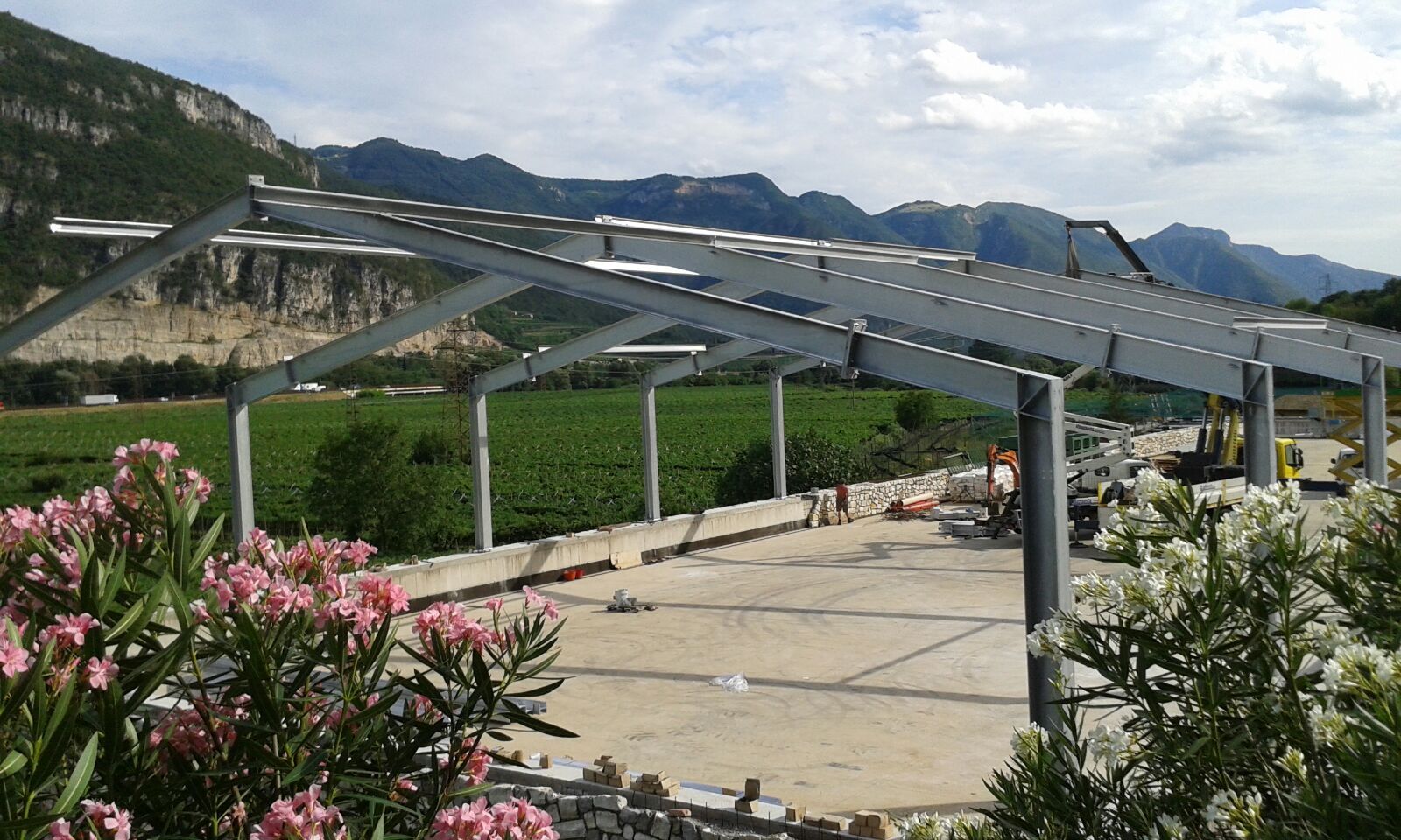 Una struttura metallica viene costruita in un campo con le montagne sullo sfondo