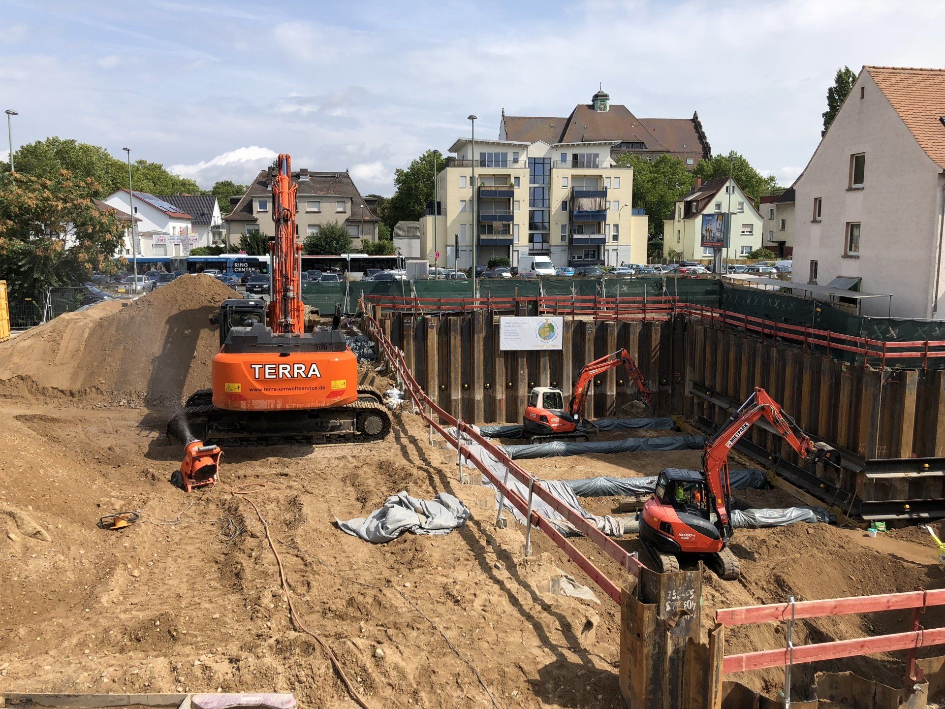 Eine Baustelle mit vielen Maschinen und Gebäuden im Hintergrund.