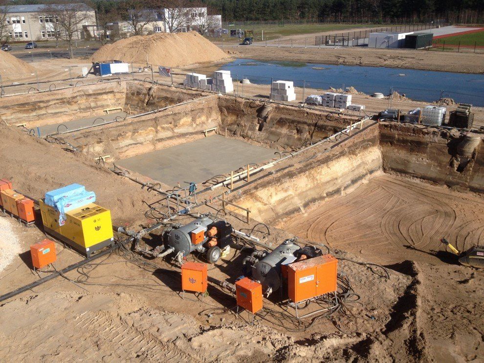 Eine Luftaufnahme einer Baustelle mit einem Fluss im Hintergrund