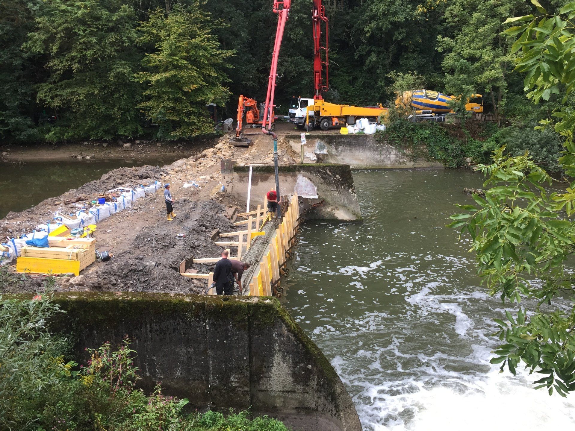 Ein Mann steht auf einer Brücke über einem Fluss.