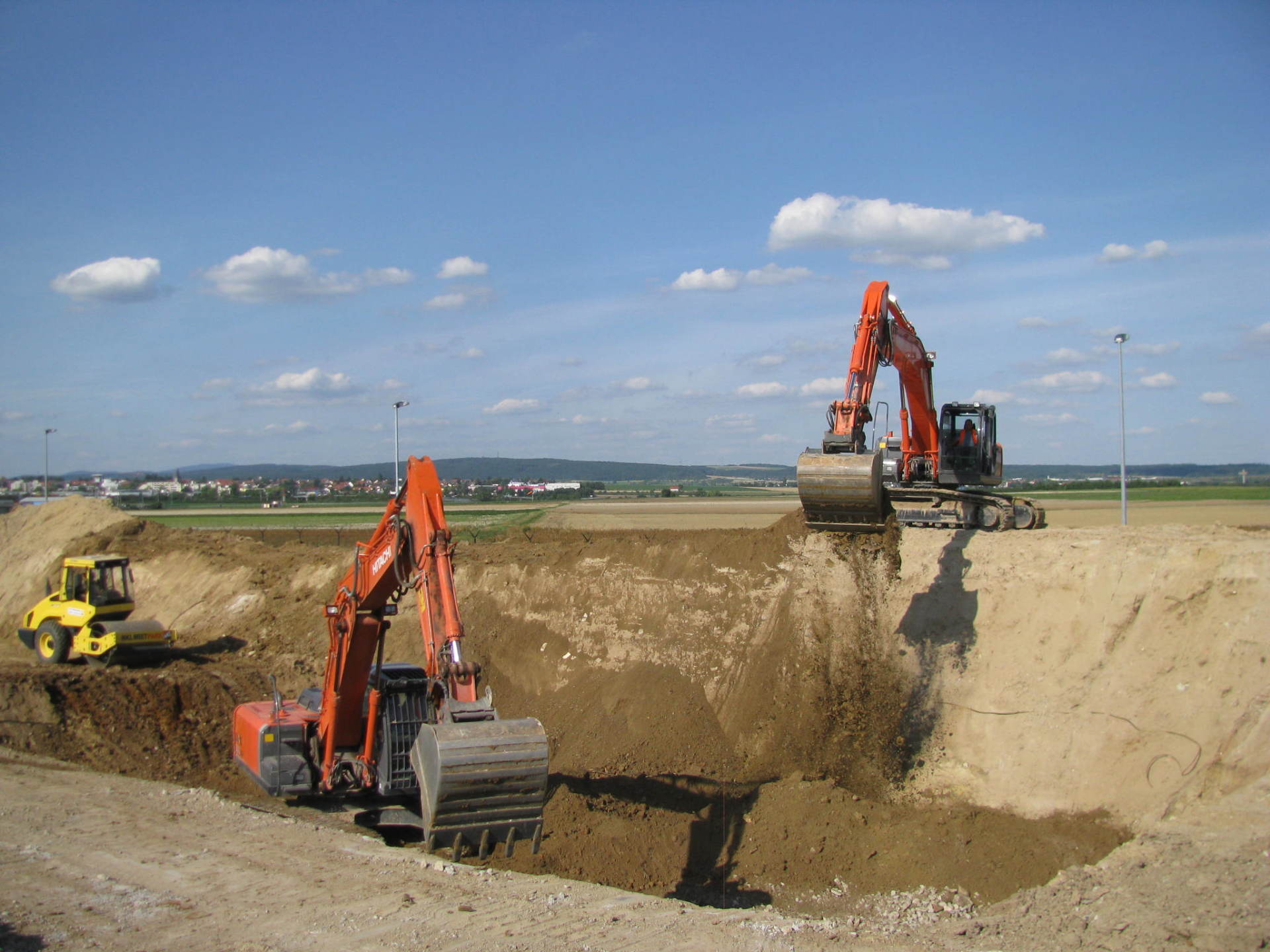 Zwei Bagger graben ein Loch in den Dreck