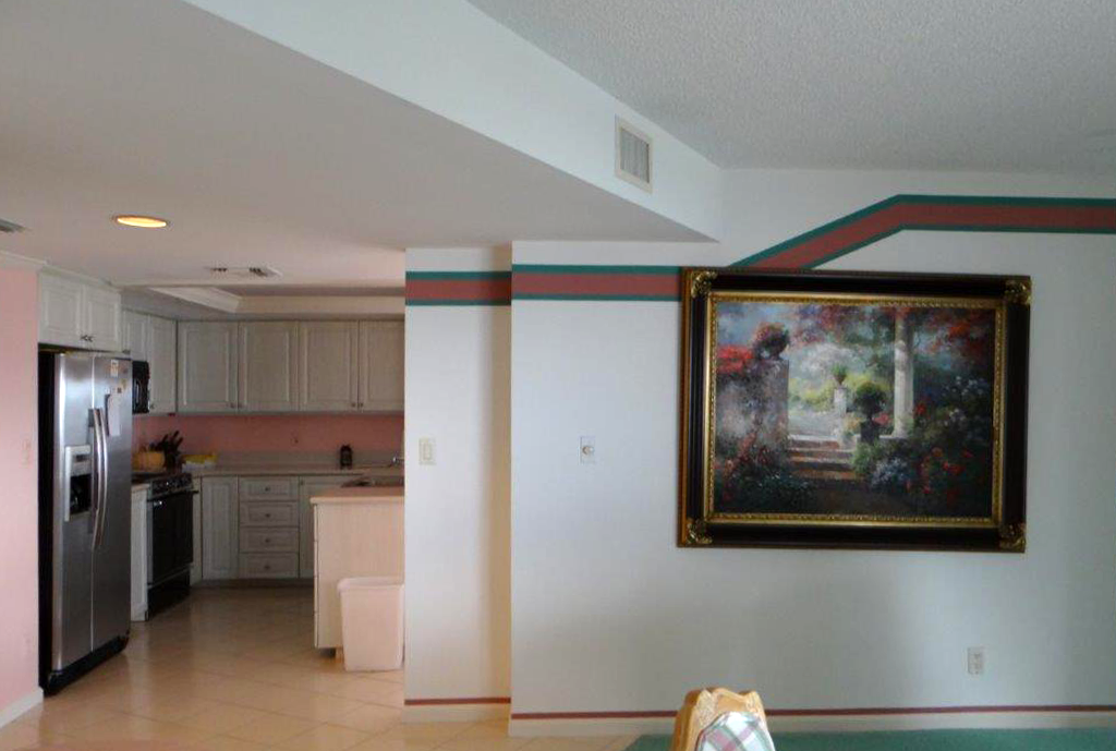 A living room with a painting on the wall.