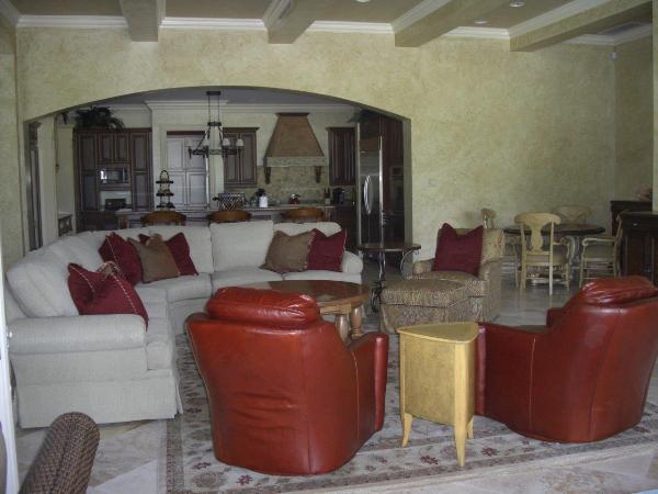 A living room with a sectional couch and red chairs.