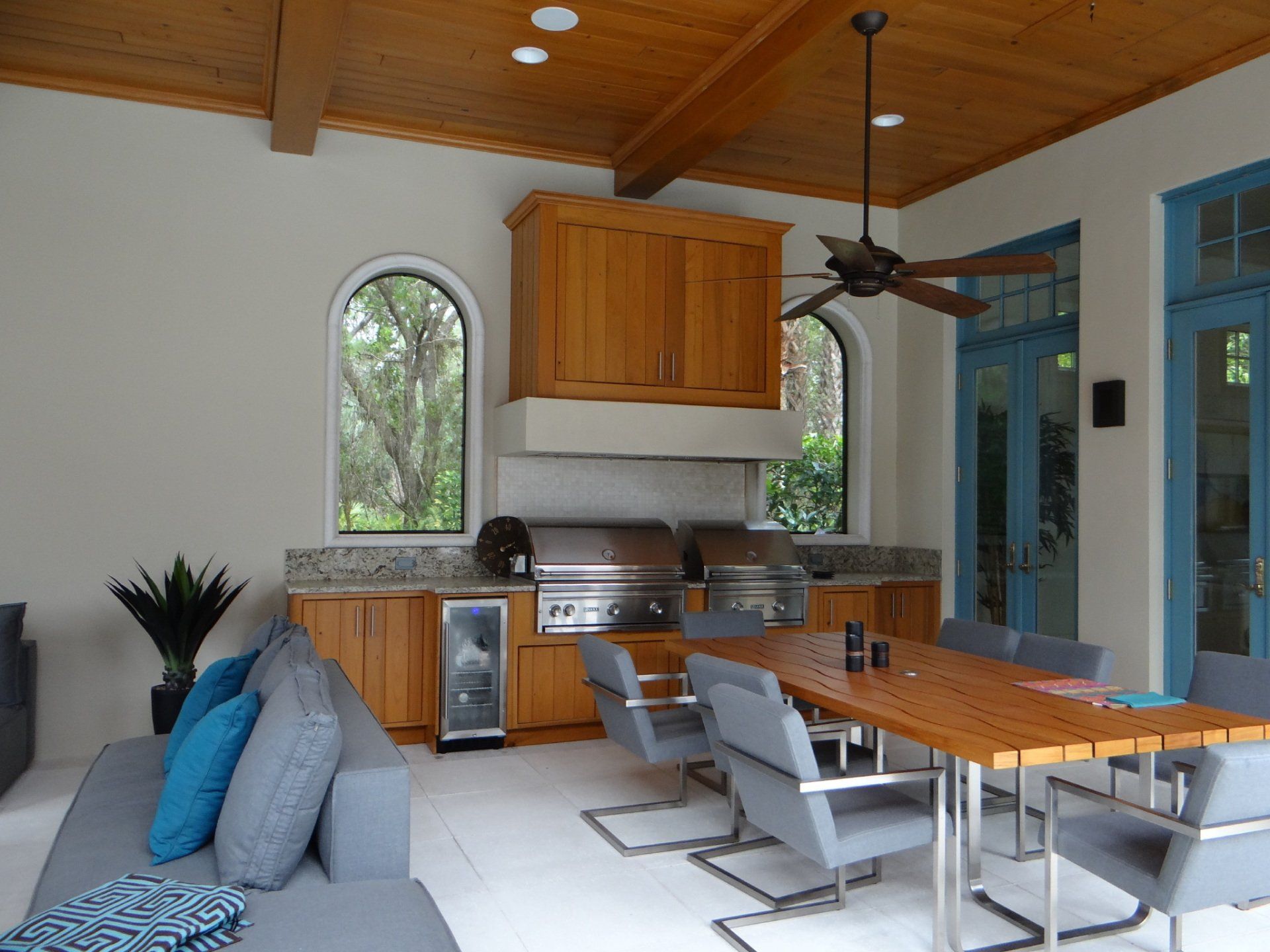 A living room with a table and chairs and a ceiling fan.