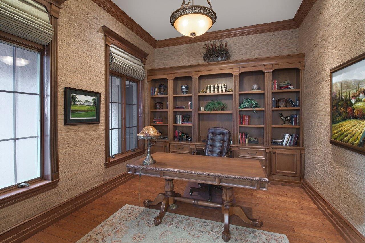 A home office with a wooden desk and chair.