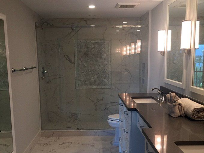 A bathroom with a toilet a sink and a walk in shower.