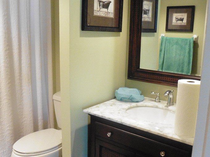 A bathroom with a toilet a sink and a mirror.