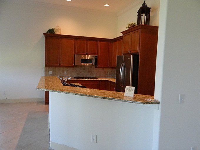 A kitchen with wooden cabinets and granite counter tops.