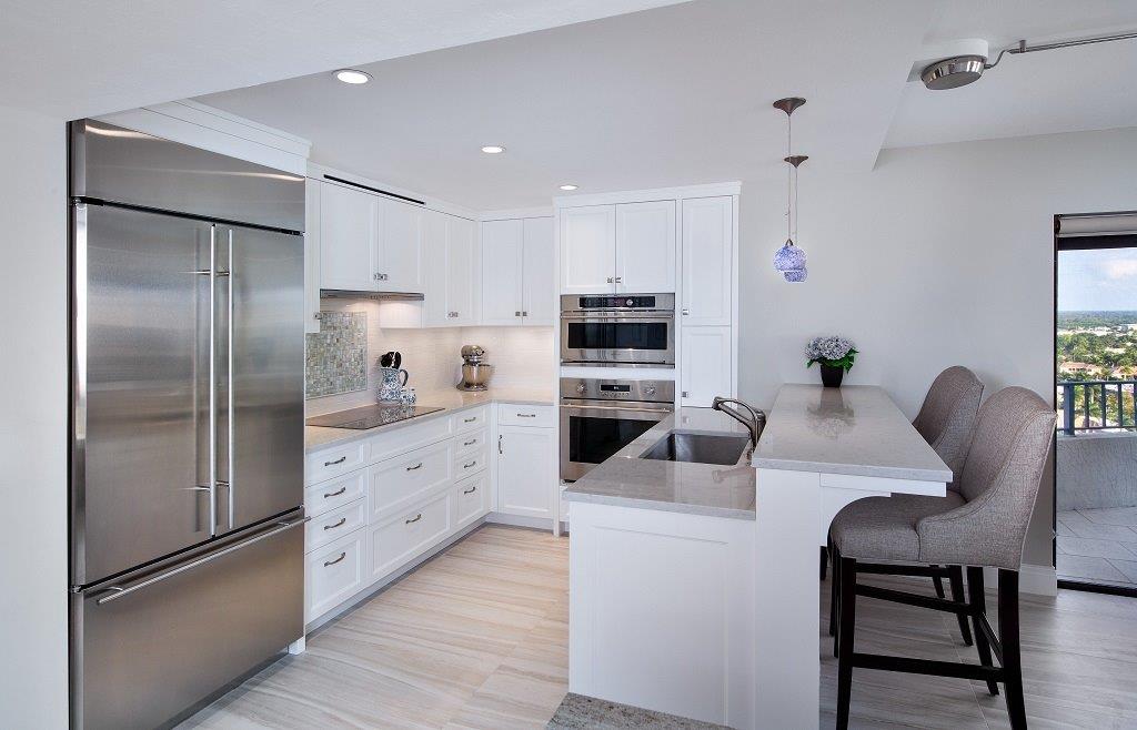 A kitchen with white cabinets and stainless steel appliances.