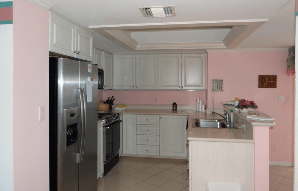 A kitchen with pink walls and stainless steel appliances.