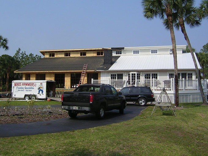 A truck is parked in front of a house that is under construction.