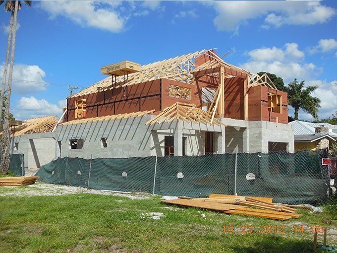 A house under construction with a fence around it.
