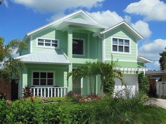 A green house with white trim and a white roof.