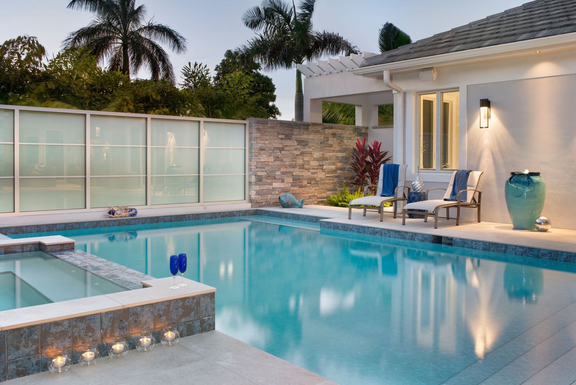 There is a large swimming pool in the backyard of a house.