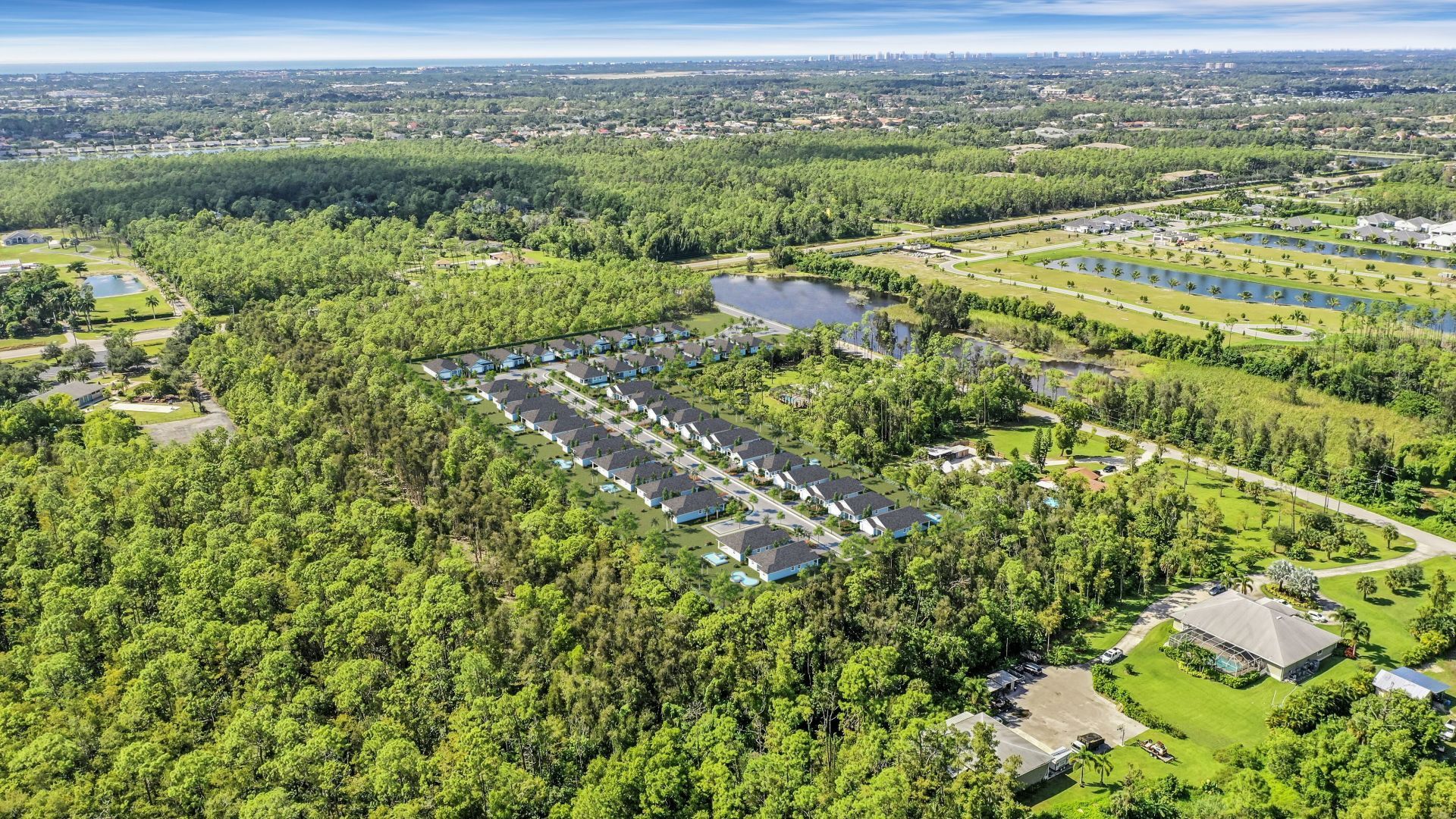An aerial view of a residential area surrounded by trees and a lake — Naples, FL — Genuine Home Builders, Inc.
