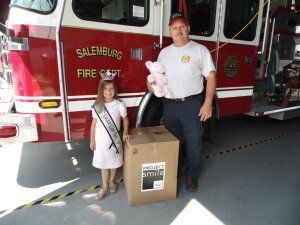 Salemburg North Carolina Fireman with kid and Project Smile Children's Donations