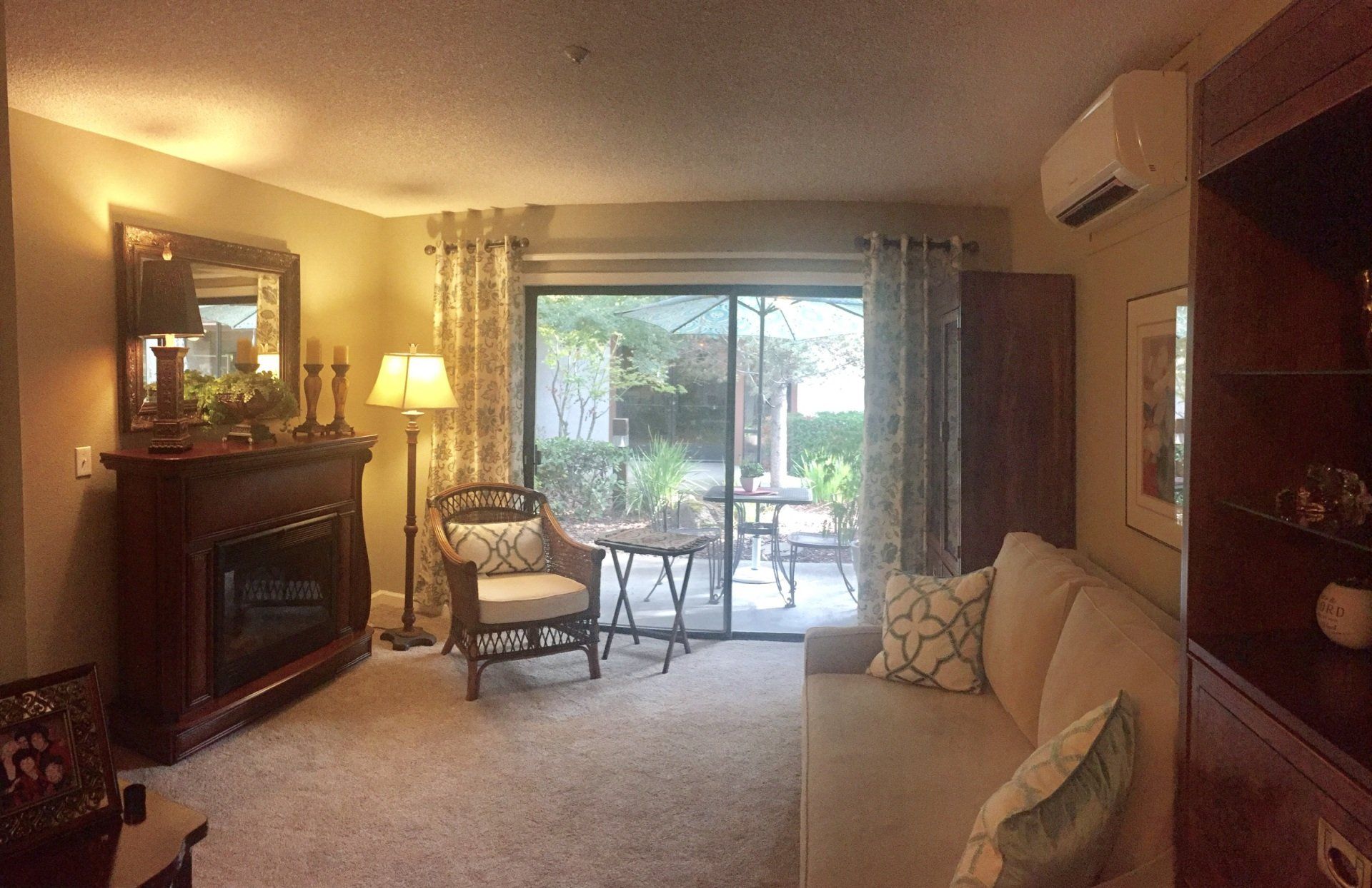 Cozy living room with a fireplace, couch, and sliding glass door leading to a patio.