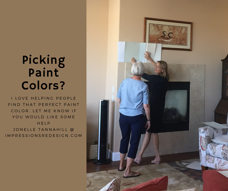 Two women selecting paint samples near a fireplace. Text: 