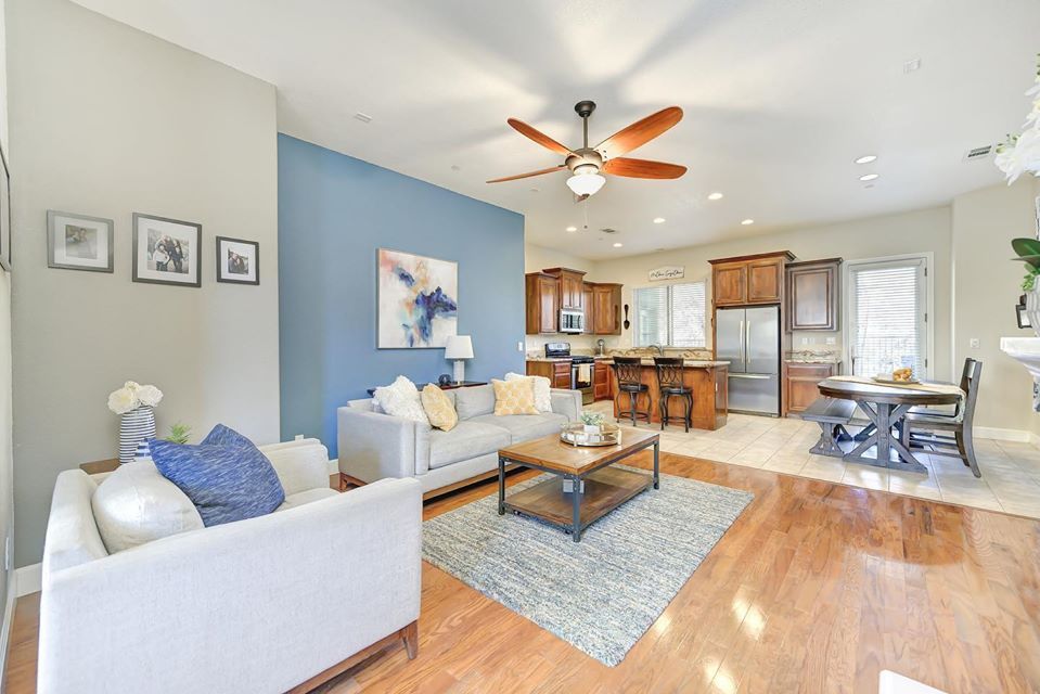 Living room with blue accent wall, sofa, coffee table, and open kitchen.