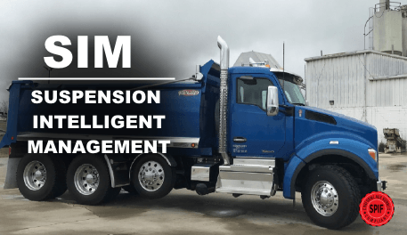 A blue dump truck is parked in front of a building.