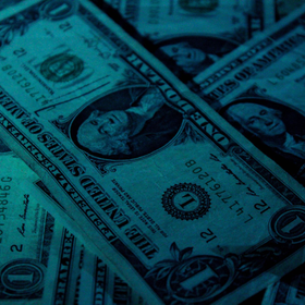 A bunch of one dollar bills are stacked on top of each other