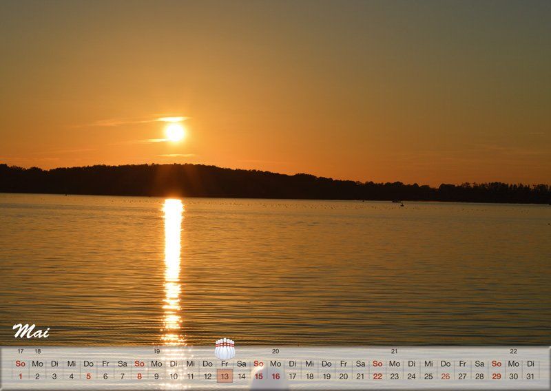 Ein Kalender zeigt einen Sonnenuntergang über einem Gewässer