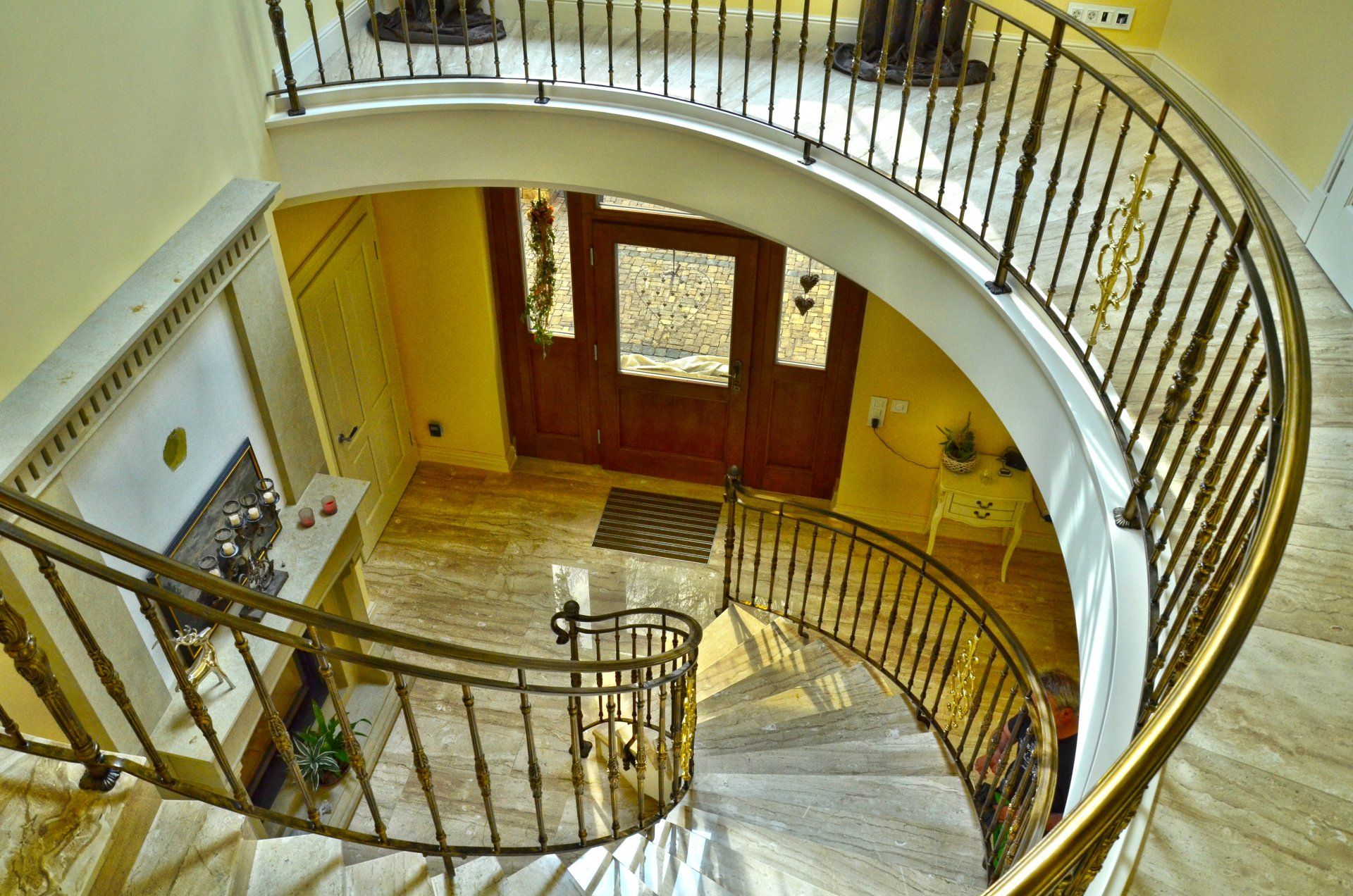 Eine Wendeltreppe mit einem schmiedeeisernen Geländer und einer Holztür