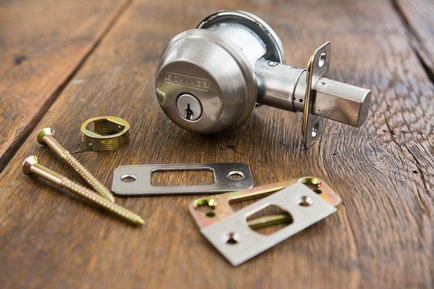 A close up of a door lock on a wooden table.