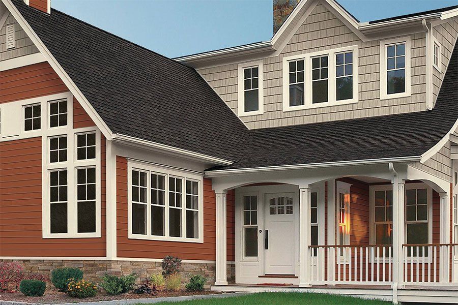 A large house with a large porch and lots of windows