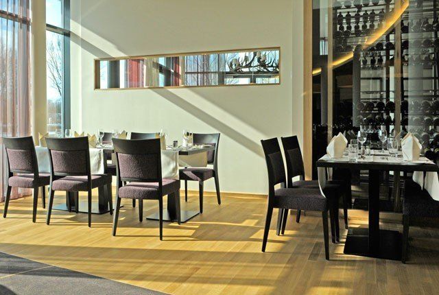 Ein Esszimmer mit Tischen und Stühlen und einem großen Fenster