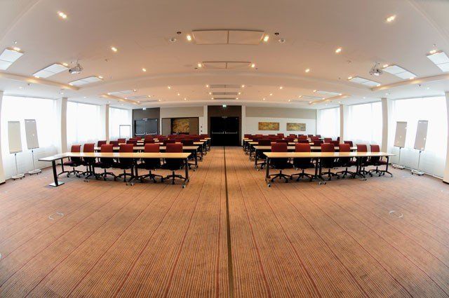 Ein großer Konferenzraum mit Tischen und Stühlen