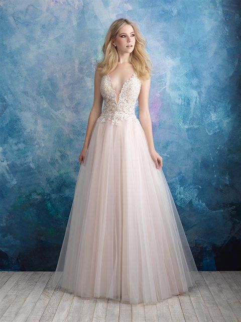 Eine Frau in einem Brautkleid steht vor einer blauen Wand.