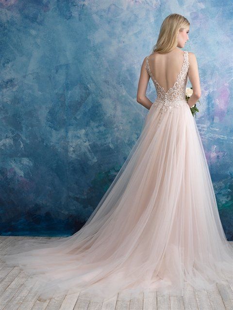 Eine Frau trägt ein rosa Brautkleid und hält einen Blumenstrauß in der Hand.