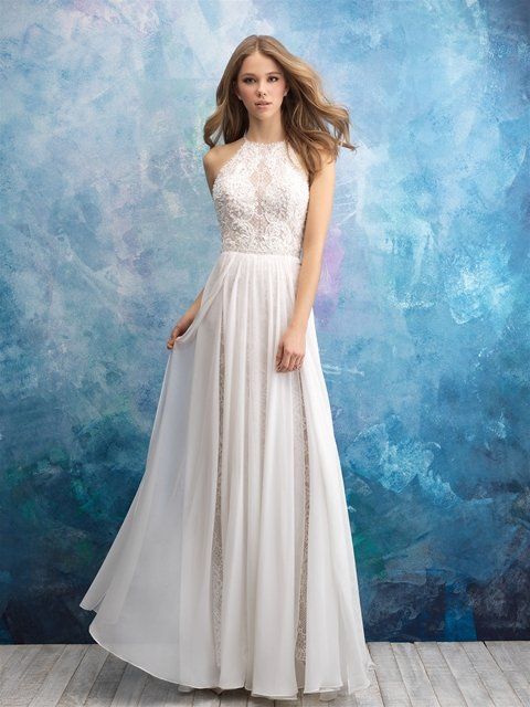 Eine Frau in einem weißen Kleid steht vor einer blauen Wand.