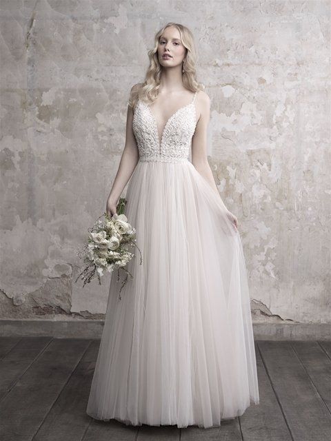Eine Frau trägt ein Brautkleid und hält einen Blumenstrauß.
